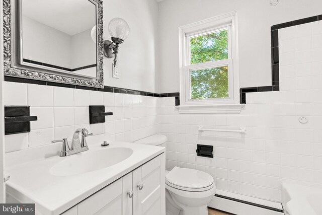 102 Deaven Rd, Harrisburg, PA 17112 - bathroom featuring baseboard heating, vanity, a bathtub, tile walls, and wainscoting