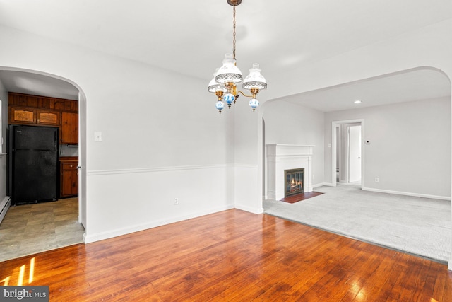 102 Deaven Rd, Harrisburg, PA 17112 - unfurnished living room featuring arched walkways, light wood-style floors, a fireplace with flush hearth, and a chandelier