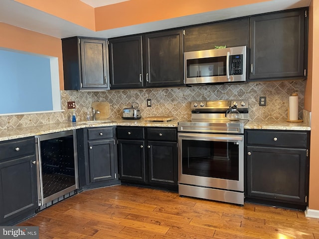 202 Meadow Ct Unit 202, Glen Mills, PA 19342 - kitchen with wine cooler, appliances with stainless steel finishes, wood finished floors, and backsplash