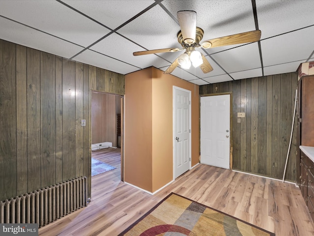 234 N Coal St, Port Carbon, PA 17965 - foyer entrance featuring wooden walls, a paneled ceiling, radiator heating unit, light wood-style flooring, and ceiling fan