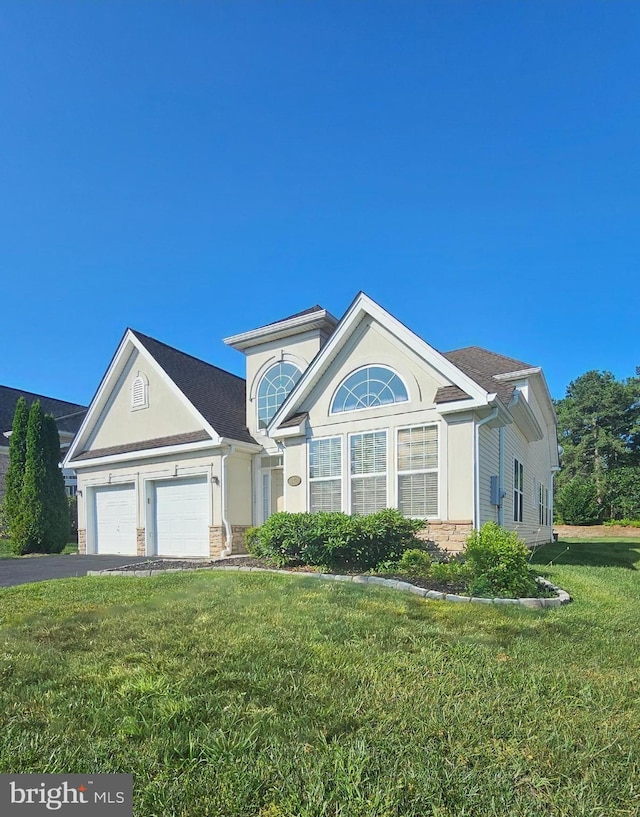 7 Honeysuckle Dr, Manahawkin, NJ 08005 - view of front facade featuring a front yard, an attached garage, stucco siding, driveway, and stone siding