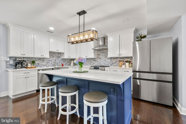 1555 Lukens Ave, Abington, PA 19001 - kitchen with appliances with stainless steel finishes, wall chimney range hood, white cabinetry, dark wood finished floors, and light countertops