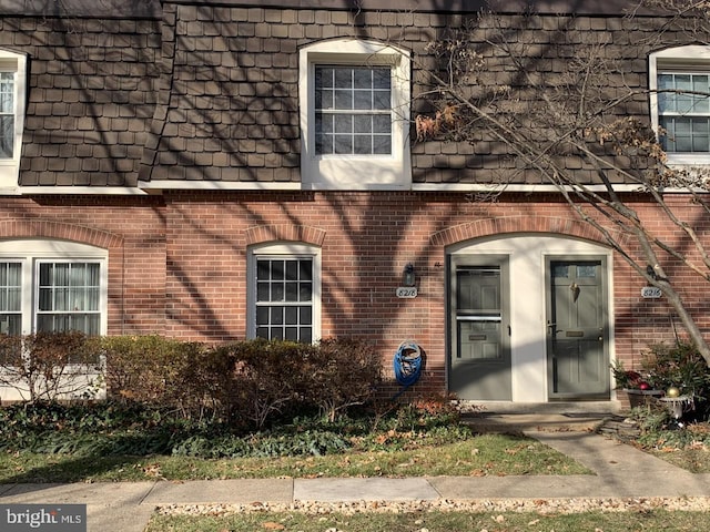 8218 Carrleigh Pkwy Unit 10, Springfield, VA 22152 - view of exterior entry featuring mansard roof and brick siding