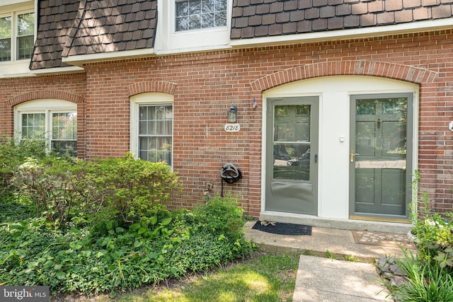 8218 Carrleigh Pkwy Unit 10, Springfield, VA 22152 - property entrance with mansard roof, brick siding, and roof with shingles