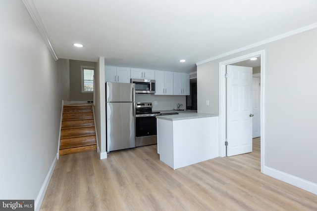 136 Chadwick Ave, Linwood, PA 19061 - kitchen featuring stainless steel appliances, crown molding, light wood-style floors, a peninsula, and light countertops