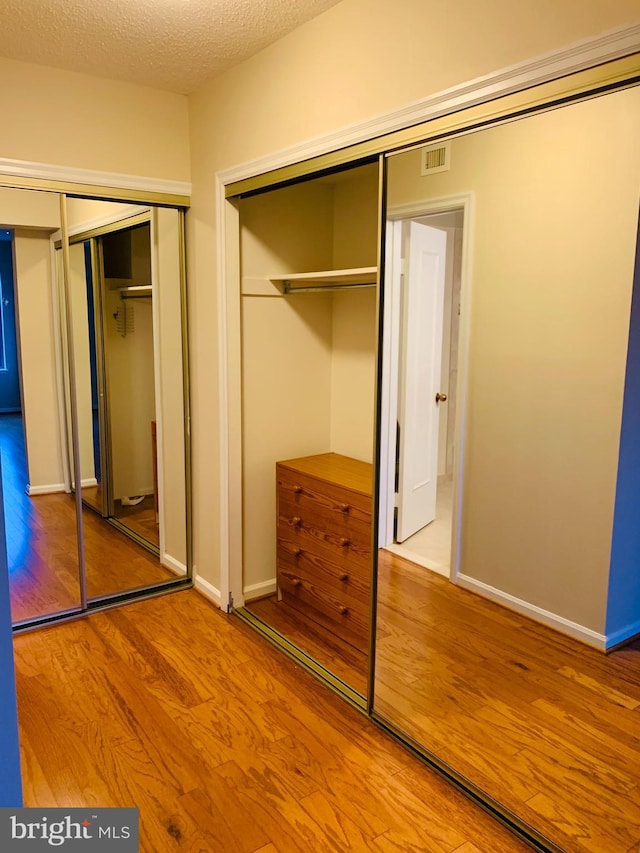 5800 Nicholson Ln Unit 1-908, Rockville, MD 20852 - unfurnished bedroom featuring wood finished floors, two closets, and a textured ceiling