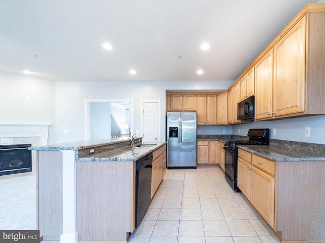 591 Odendhal Ave Unit 591, Gaithersburg, MD 20877 - kitchen featuring black appliances, light brown cabinets, light tile patterned floors, dark stone counters, and a kitchen island with sink