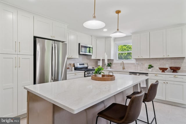 805 Windsor Cir, Folcroft, PA 19032 - kitchen with stainless steel appliances, white cabinets, backsplash, a center island, and a kitchen breakfast bar
