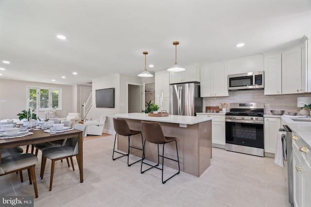 805 Windsor Cir, Folcroft, PA 19032 - kitchen featuring appliances with stainless steel finishes, open floor plan, a kitchen island, a breakfast bar, and light countertops