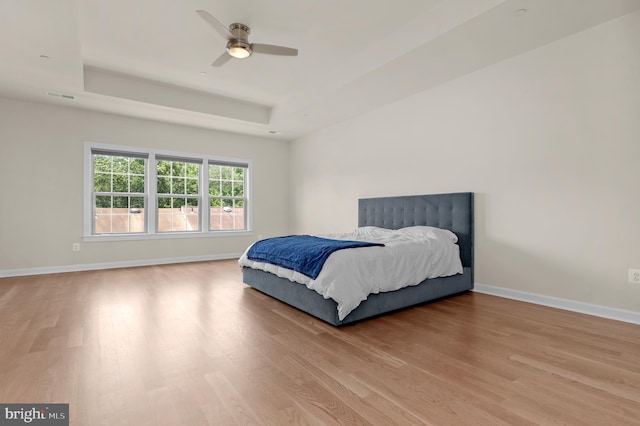 1025 Mutual Pl, Sandy Spring, MD 20860 - bedroom featuring a tray ceiling, light wood finished floors, and a ceiling fan