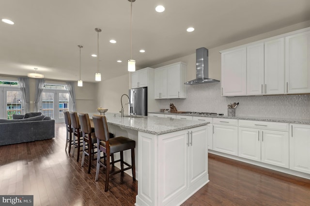 1025 Mutual Pl, Sandy Spring, MD 20860 - kitchen featuring wall chimney range hood, stainless steel appliances, dark wood-style flooring, white cabinets, and recessed lighting