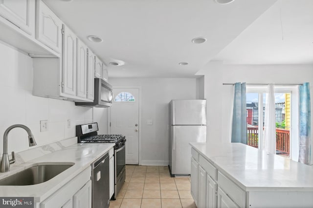 1816 Chilton St, Baltimore, MD 21218 - kitchen featuring stainless steel appliances, light tile patterned floors, white cabinets, a kitchen island, and recessed lighting