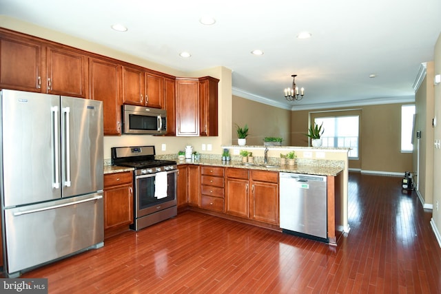42825 Pamplin Ter, Chantilly, VA 20152 - kitchen featuring appliances with stainless steel finishes, a peninsula, a chandelier, crown molding, and brown cabinetry