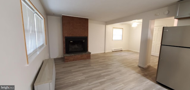 53 Snow Bird Trl, Fairfield, PA 17320 - unfurnished living room with ceiling fan, baseboard heating, a large fireplace, and light wood-style floors