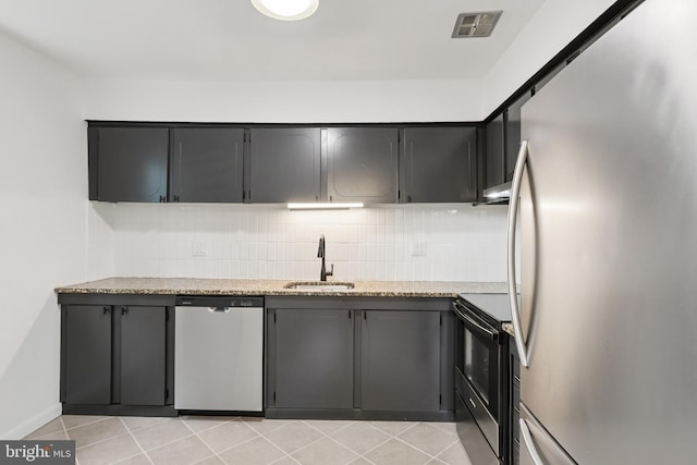 4000 Gypsy Ln Unit 529, Philadelphia, PA 19129 - kitchen with appliances with stainless steel finishes, decorative backsplash, light tile patterned floors, and light stone countertops