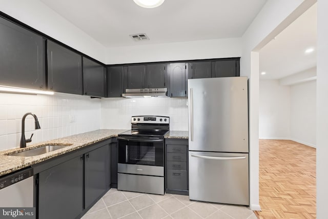 4000 Gypsy Ln Unit 529, Philadelphia, PA 19129 - kitchen featuring appliances with stainless steel finishes, under cabinet range hood, light stone counters, and backsplash