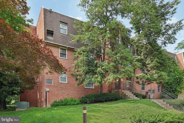 4000 Gypsy Ln Unit 529, Philadelphia, PA 19129 - view of side of property featuring mansard roof, a yard, and brick siding