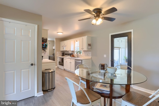 112 Lynmar Ave, Palmyra, PA 17078 - dining area with light wood finished floors, a ceiling fan, and washer and clothes dryer