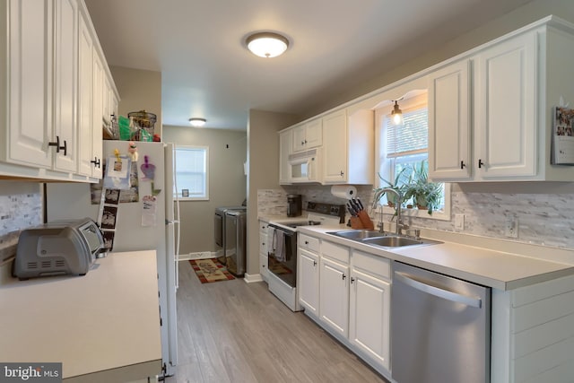 112 Lynmar Ave, Palmyra, PA 17078 - kitchen featuring white appliances, separate washer and dryer, white cabinets, decorative backsplash, and light wood-style flooring
