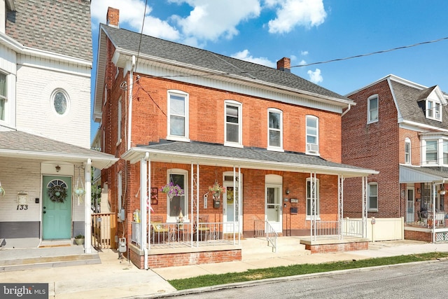 137 S E St, Spring Grove, PA 17362 - view of property with a chimney, brick siding, a porch, and roof with shingles