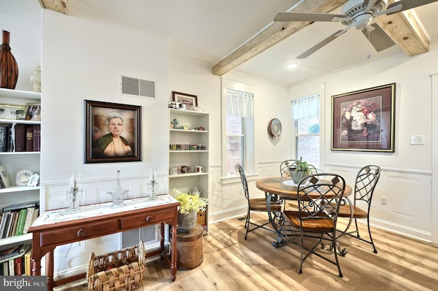 137 S E St, Spring Grove, PA 17362 - dining room featuring beamed ceiling, light wood finished floors, a ceiling fan, a decorative wall, and a wainscoted wall
