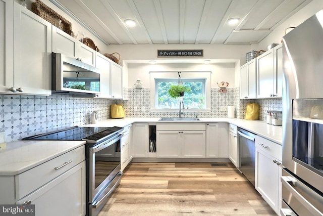 137 S E St, Spring Grove, PA 17362 - kitchen featuring stainless steel appliances, light wood-style floors, white cabinets, light countertops, and backsplash