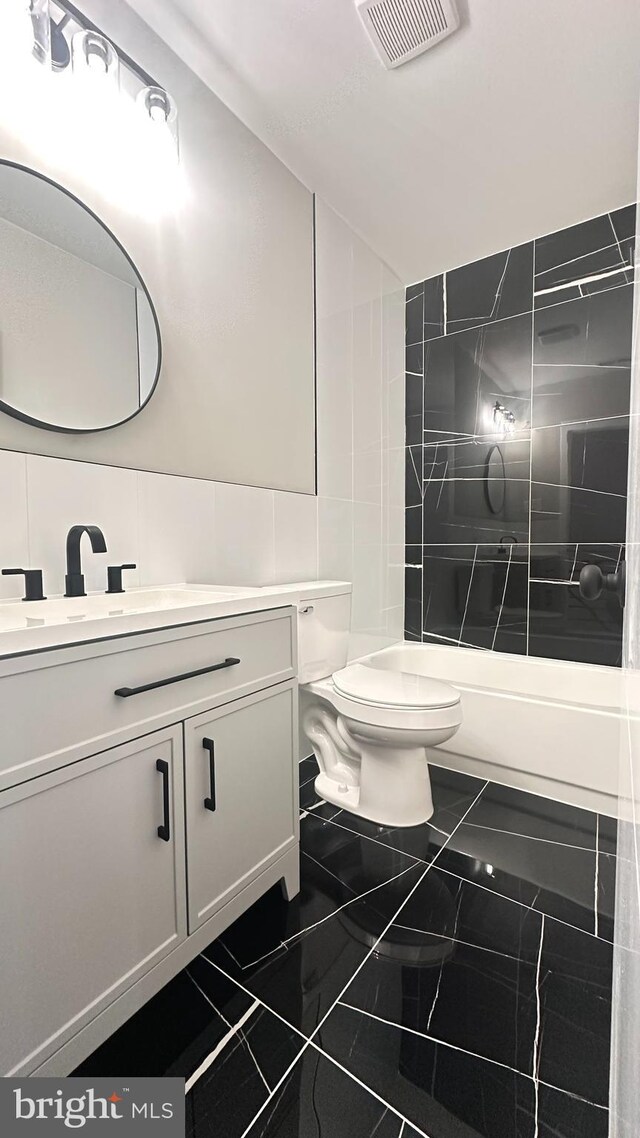 5841 Cedarhurst St, Philadelphia, PA 19143 - bathroom featuring marble finish floors, vanity, washtub / shower combination, and tile walls