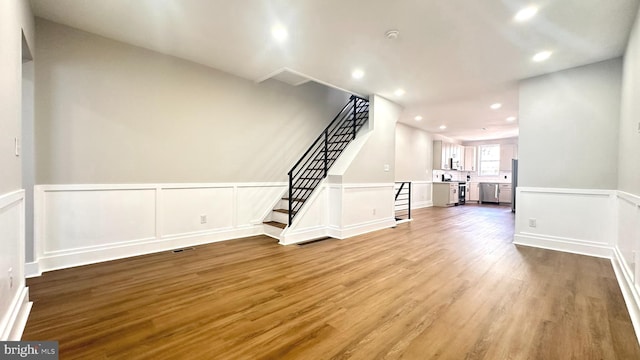 5841 Cedarhurst St, Philadelphia, PA 19143 - unfurnished living room with stairway, wood finished floors, recessed lighting, a wainscoted wall, and a decorative wall