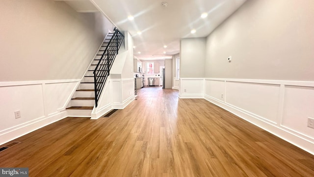 5841 Cedarhurst St, Philadelphia, PA 19143 - unfurnished living room with light wood-type flooring, stairway, a decorative wall, wainscoting, and recessed lighting