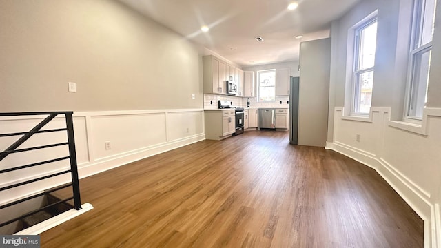 5841 Cedarhurst St, Philadelphia, PA 19143 - unfurnished living room featuring dark wood-style floors and a wainscoted wall