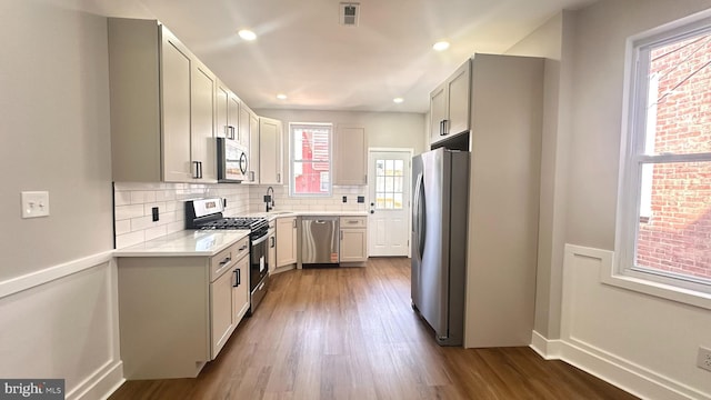 5841 Cedarhurst St, Philadelphia, PA 19143 - kitchen featuring stainless steel appliances, light countertops, decorative backsplash, dark wood finished floors, and recessed lighting