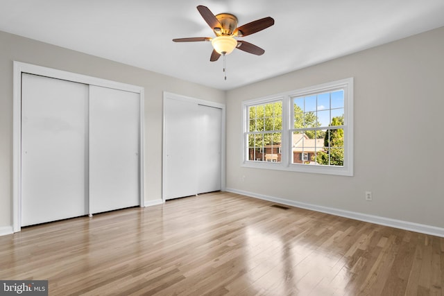 8384 Forrester Blvd, Springfield, VA 22152 - unfurnished bedroom with two closets, light wood-type flooring, and a ceiling fan