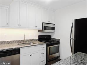 23311 Sugar Maple Ct Unit 1, California, MD 20619 - kitchen featuring stainless steel appliances, white cabinets, and light stone countertops