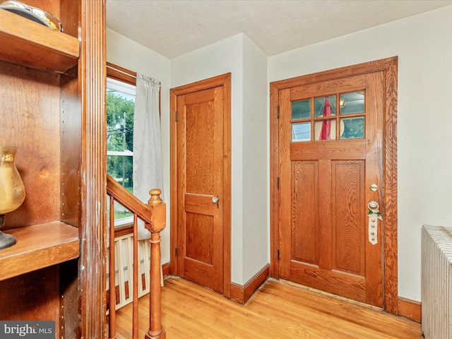 21127 Twin Springs Dr, Smithsburg, MD 21783 - foyer featuring radiator, light wood-style flooring, and a textured ceiling