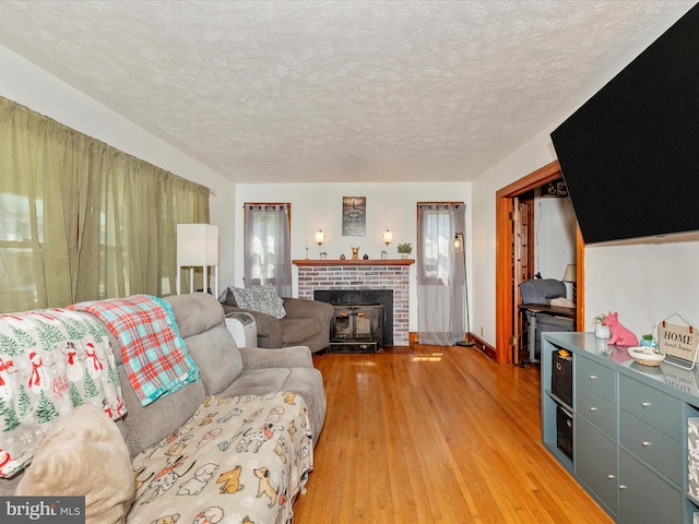 21127 Twin Springs Dr, Smithsburg, MD 21783 - living area featuring light wood-type flooring, a textured ceiling, and a fireplace