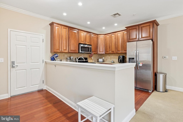 300 W Elm St Unit 2104, Conshohocken, PA 19428 - kitchen with appliances with stainless steel finishes, a peninsula, backsplash, crown molding, and recessed lighting