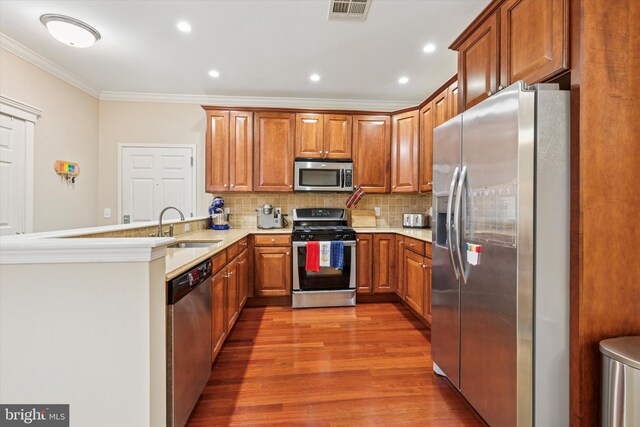 300 W Elm St Unit 2104, Conshohocken, PA 19428 - kitchen featuring stainless steel appliances, ornamental molding, brown cabinetry, wood finished floors, and a peninsula
