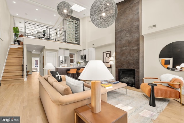 2431 Ontario Rd NW Unit 4, Washington, DC 20009 - living area with a high ceiling, stairway, light wood-type flooring, a tile fireplace, and recessed lighting