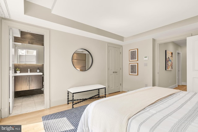 2431 Ontario Rd NW Unit 4, Washington, DC 20009 - bedroom featuring a raised ceiling, light wood-style floors, and ensuite bath
