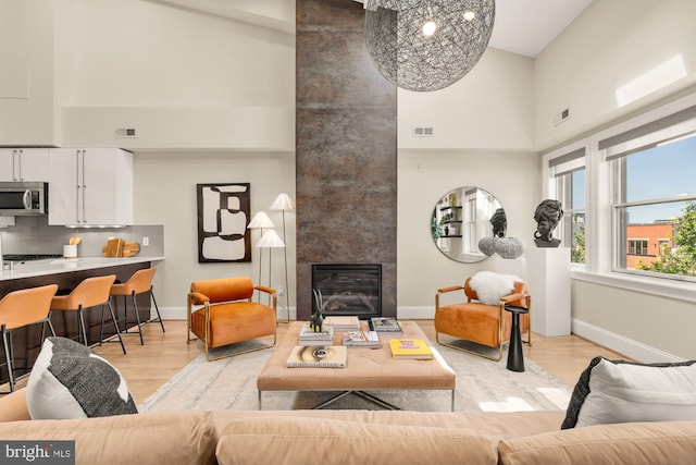 2431 Ontario Rd NW Unit 4, Washington, DC 20009 - living area with a high ceiling, light wood finished floors, a tile fireplace, and a chandelier