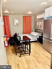 2647 N 17th St, Philadelphia, PA 19132 - dining area featuring a wall mounted AC and wood finished floors