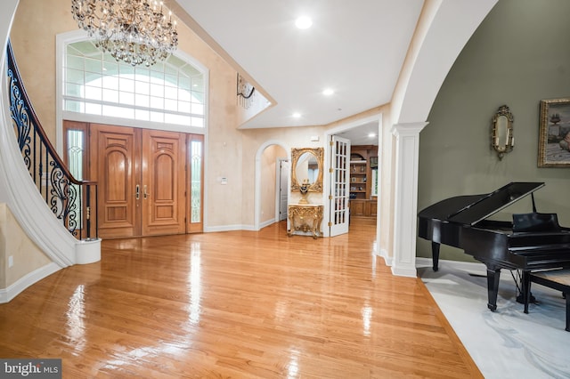 1126 Timbergate Dr, Jenkintown, PA 19046 - foyer entrance with arched walkways, a chandelier, decorative columns, wood finished floors, and a towering ceiling
