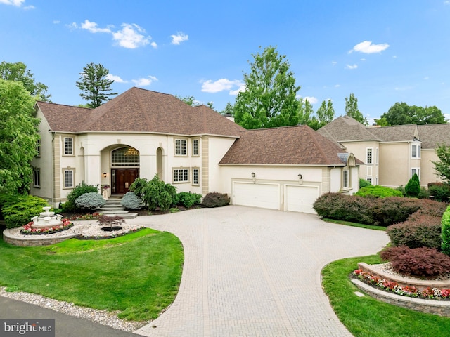 1126 Timbergate Dr, Jenkintown, PA 19046 - french country home featuring a garage, decorative driveway, stucco siding, roof with shingles, and a front lawn