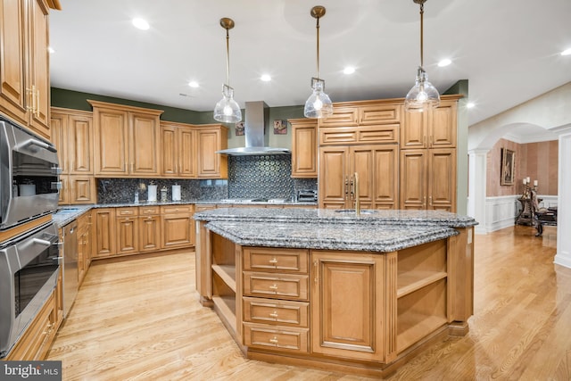 1126 Timbergate Dr, Jenkintown, PA 19046 - kitchen featuring open shelves, wall chimney range hood, a kitchen island with sink, arched walkways, and light wood-type flooring