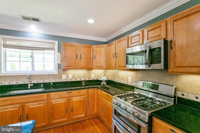5722 Larpin Ln, Alexandria, VA 22310 - kitchen featuring stainless steel appliances, ornamental molding, light wood finished floors, backsplash, and brown cabinetry