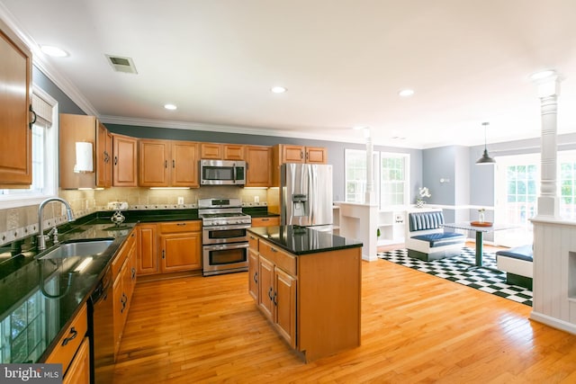 5722 Larpin Ln, Alexandria, VA 22310 - kitchen featuring appliances with stainless steel finishes, light wood-style flooring, tasteful backsplash, crown molding, and a center island