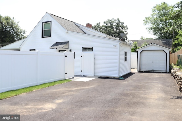 848 Grakyn Ln, Philadelphia, PA 19128 - view of front of house with an outdoor structure, a garage, and a chimney