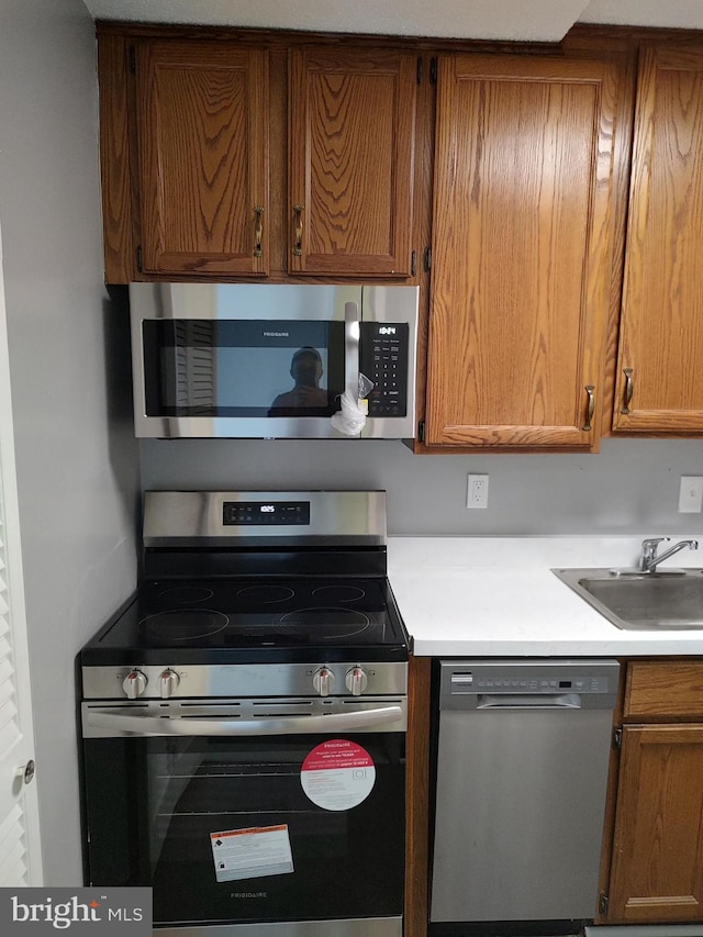 1301 Delaware Ave SW Unit N103, Washington, DC 20024 - kitchen featuring appliances with stainless steel finishes, brown cabinetry, and light countertops