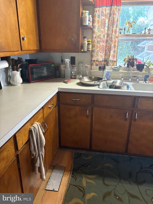 23069 Raleigh Rd, Chestertown, MD 21620 - kitchen with black microwave, light countertops, and brown cabinetry
