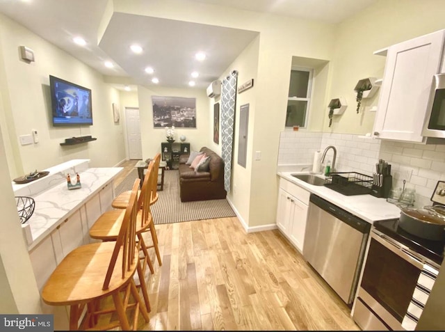 2538 N 16th St, Philadelphia, PA 19132 - kitchen with stainless steel appliances, open shelves, light wood-style flooring, white cabinets, and recessed lighting